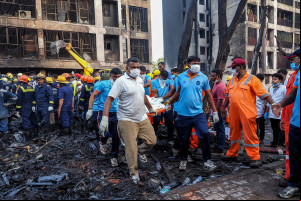  Rescue officials carry a victim's body at the site where Air India flight 171 crashed in a residential area near the airport in Ahmedabad on June 12, 2025. A London-bound enger plane crashed in the Indian city of Ahmedabad on June 12 and all 242 people on board were believed killed, with the jet smashing into buildings housing doctors and their families. (Photo by Sam PANTHAKY / AFP)