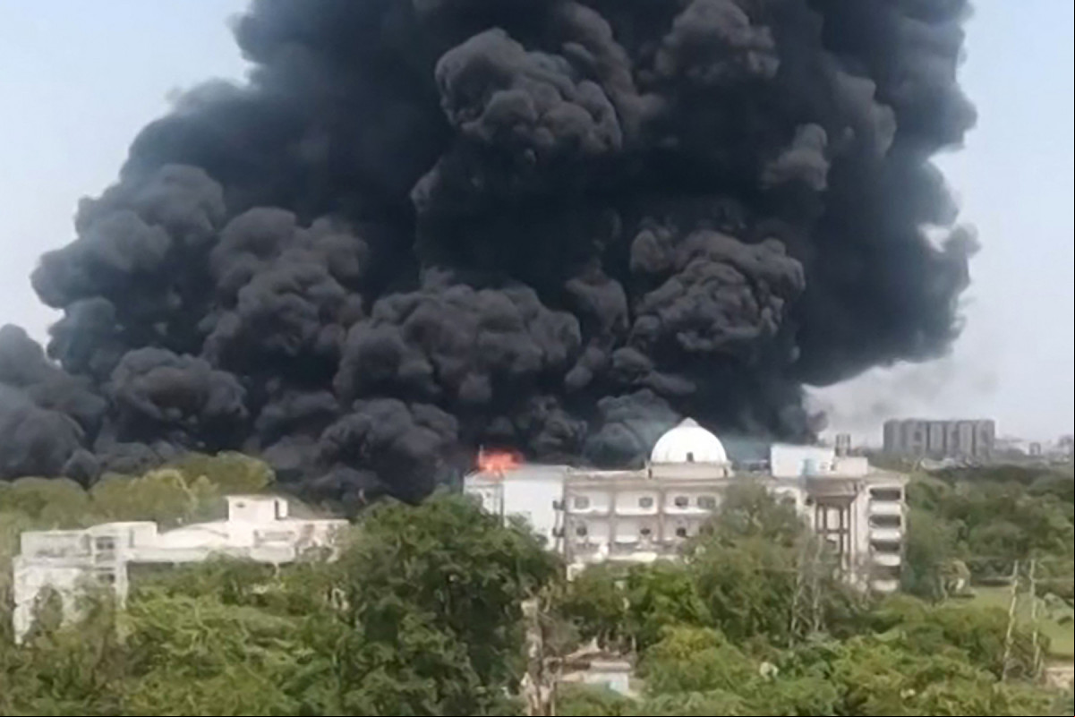 Esta captura de tela de um vídeo da UGC mostra uma densa fumaça preta subindo de uma área residencial após a queda do voo 171 da Air India em Ahmedabad, em 12 de junho de 2025. Equipes de resgate com cães farejadores vasculharam o local do acidente em 13 de junho do jato de ageiros com destino a Londres, que atingiu uma área residencial da cidade de Ahmedabad, na Índia, matando pelo menos 265 pessoas a bordo e no solo. (Foto de Vijay Patani / AFP)
