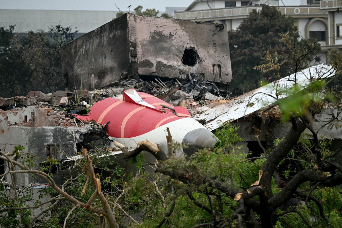 
Os destroços do voo 171 da Air India são fotografados após a queda em uma área residencial perto do aeroporto de Ahmedabad, em 13 de junho de 2025. Equipes de resgate com cães farejadores vasculharam o local do acidente, em 13 de junho, de um jato de ageiros com destino a Londres que se chocou contra uma área residencial da cidade de Ahmedabad, na Índia, matando pelo menos 265 pessoas a bordo e em solo. (Foto de Punit PARANJPE / AFP)
